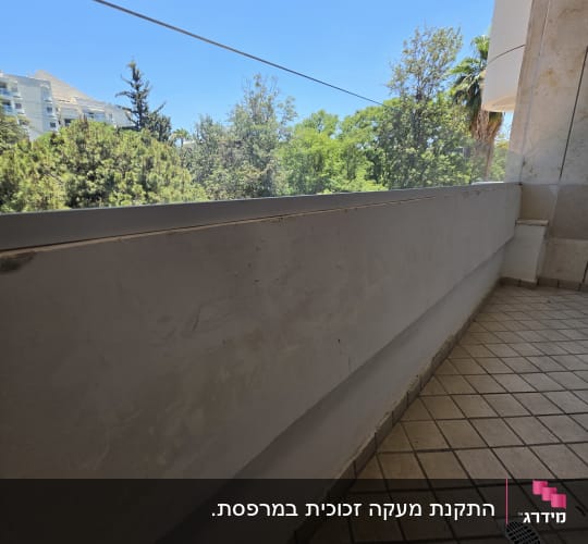 מרפסת עם מעקה זכוכית ונוף עצים